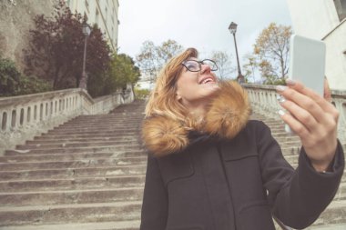 Sevimli kız sokakta cep telefonu kullanarak.