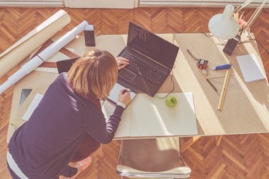 Parlak güneşli oda bir projede çalışan kadın mimar.