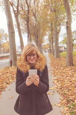 Sevimli kız sokakta cep telefonu kullanarak.