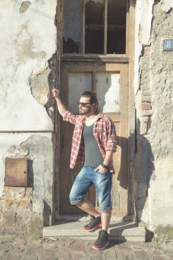 Adam harap evin önünde poz uzun saç ve sakal ile.