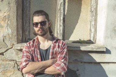 Adam harap evin önünde poz uzun saç ve sakal ile.