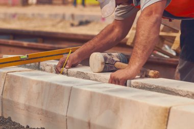 Beton bloklar tesviye teyp ölçme ile gerçek inşaat işçisi.
