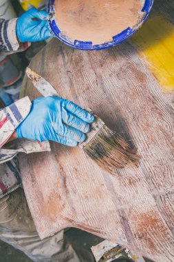 Yapay ahşap doku yapmak için boya fırçası kullanarak sanatçı.