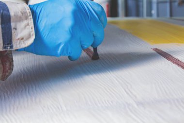 Yapay ahşap doku yapmak için boya fırçası kullanarak sanatçı.