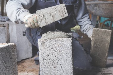 Gerçek inşaat işçisi aletleri kullanarak duvarı örüyor..