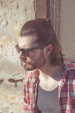 Adam harap evin önünde poz uzun saç ve sakal ile.