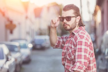Yakışıklı genç adam sokakta poz.