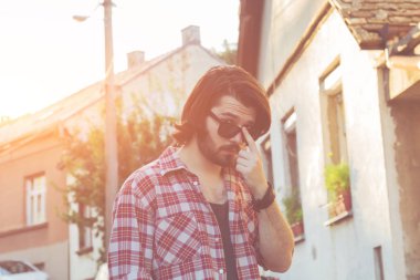 Yakışıklı genç adam sokakta poz.