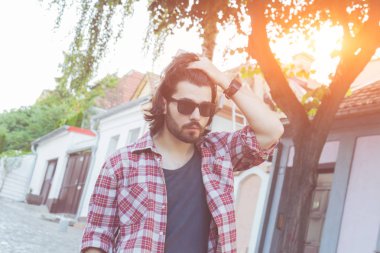 Yakışıklı genç adam sokakta poz.