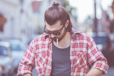 Sokakta sigara içen genç bir adam..