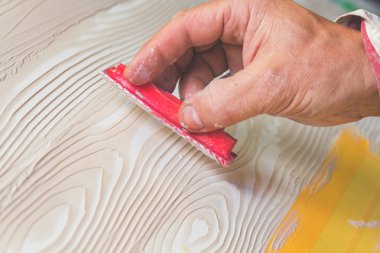 Yapay ahşap doku yapmak için aracını kullanarak sanatçı.