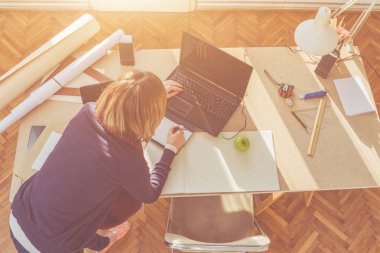 Parlak güneşli oda bir projede çalışan kadın mimar.