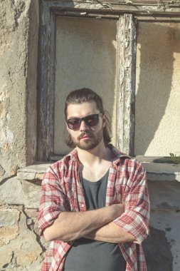 Adam harap evin önünde poz uzun saç ve sakal ile.