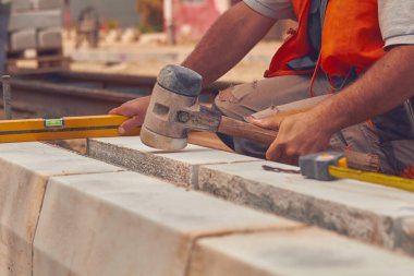 Beton bloklar tesviye teyp ölçme ile gerçek inşaat işçisi.