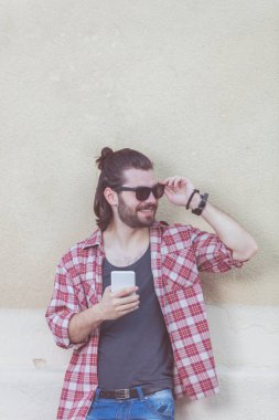 Sokakta bir cep telefonu ile genç adam.