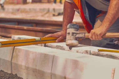Beton bloklar tesviye teyp ölçme ile gerçek inşaat işçisi.