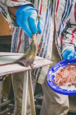 Yapay ahşap doku yapmak için boya fırçası kullanarak sanatçı.