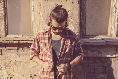 Adam harap evin önünde poz uzun saç ve sakal ile.