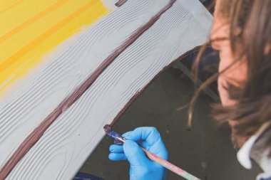 Yapay ahşap doku yapmak için boya fırçası kullanarak sanatçı.