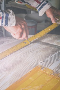 Yapay ahşap doku yapmak için aracını kullanarak sanatçı.