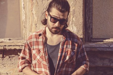 Adam harap evin önünde poz uzun saç ve sakal ile.