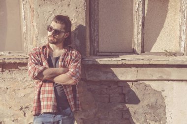 Adam harap evin önünde poz uzun saç ve sakal ile.