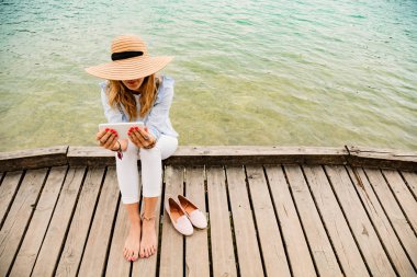 Kız smartphone kullanarak bir ahşap iskele üzerinde.