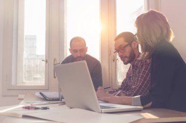 Güneşli bir ofiste Genç Mimarlar grubu.