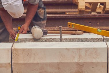 Beton bloklar tesviye teyp ölçme ile gerçek inşaat işçisi.