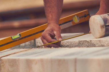 Beton bloklar tesviye teyp ölçme ile gerçek inşaat işçisi.
