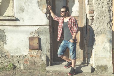 Adam harap evin önünde poz uzun saç ve sakal ile.