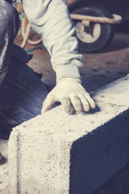 Gerçek inşaat işçisi aletleri kullanarak duvarı örüyor..