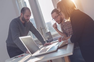 Güneşli bir ofiste Genç Mimarlar grubu.