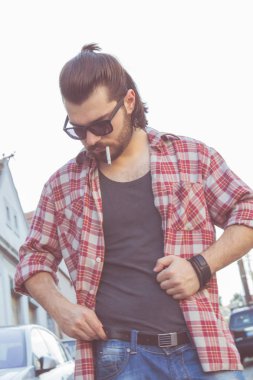 Sokakta sigara içen genç bir adam..