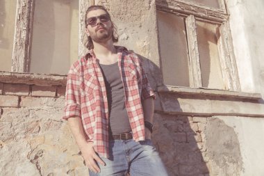 Adam harap evin önünde poz uzun saç ve sakal ile.