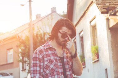 Yakışıklı genç adam sokakta poz.