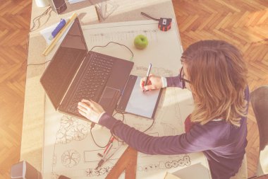 Parlak güneşli oda bir projede çalışan kadın mimar.