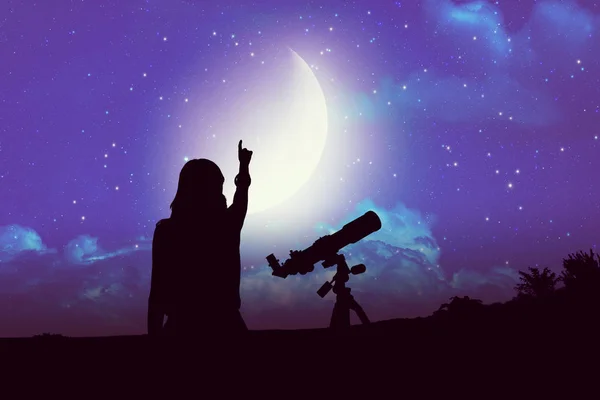 Silhouette of a girl beside astronomy telescope with Moon and Milky Way stars. Elements of this image are my astronomy work.