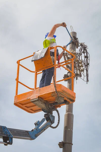 Power line worker fixing from the truck basket.