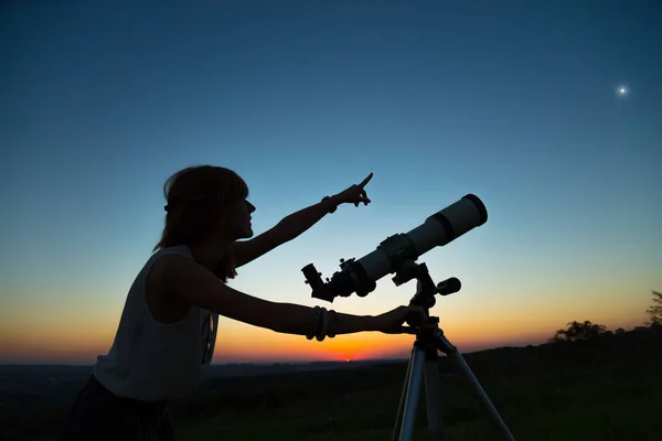 用天文望远镜看天空的年轻女子 — 图库照片