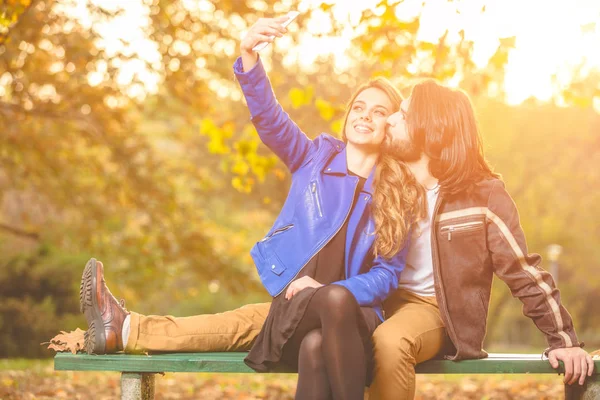 Junges Paar Benutzt Handy Herbstlich Gefärbten Park — Stockfoto