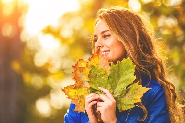 可愛いです笑顔の女性は自然の中で紅葉を保持 — ストック写真