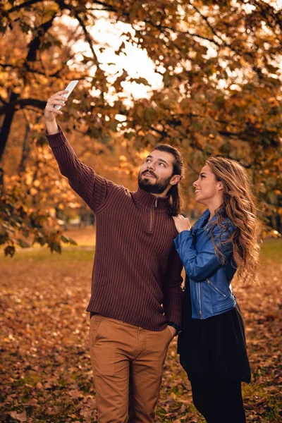 Fiatal Pár Őszi Színes Park Mobiltelefon Segítségével — Stock Fotó