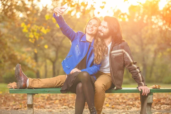 Junges Paar Benutzt Handy Herbstlich Gefärbten Park — Stockfoto