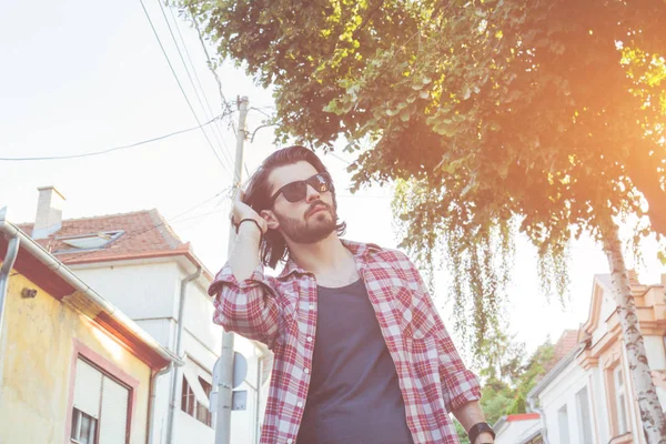 Yakışıklı genç adam sokakta poz.