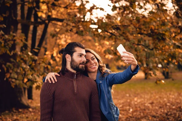 Fiatal Pár Őszi Színes Park Mobiltelefon Segítségével — Stock Fotó