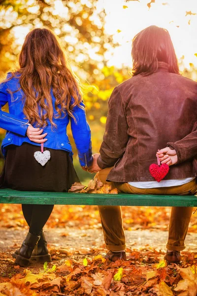 公園のベンチにハート形を保持しているカップル — ストック写真