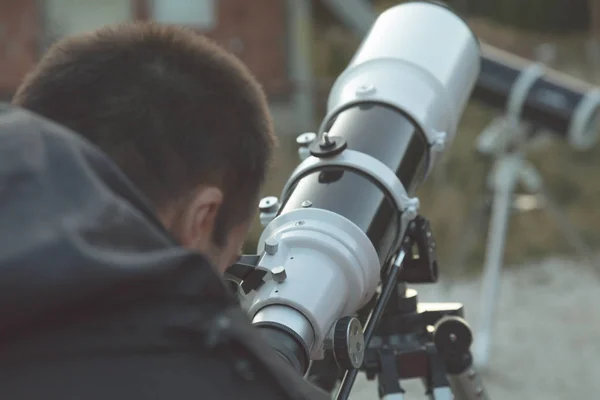屋外の望遠鏡を通して見るアマチュア天文学者 — ストック写真
