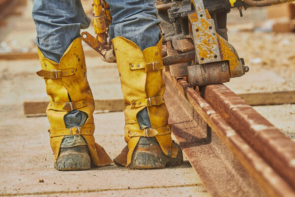 Construction worker welding iron train tracks.