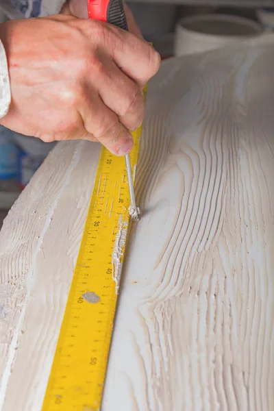 Artist using tool for making artificial wood texture.
